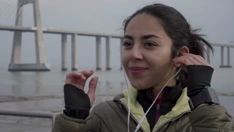 Smiling-young-woman-wearing-earphones